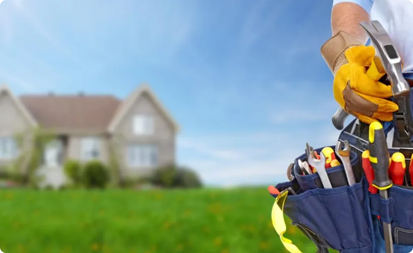 A service professional with a tool belt in front of a home